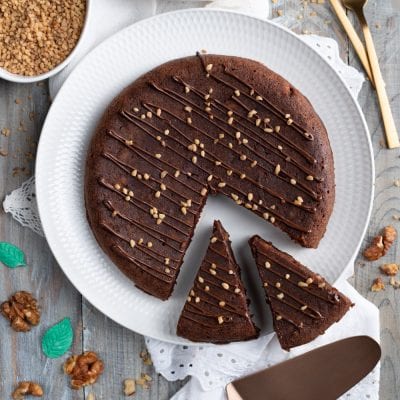 Torta brownies con glassa al cioccolato colata e granella di nocciole, tagliata a fette