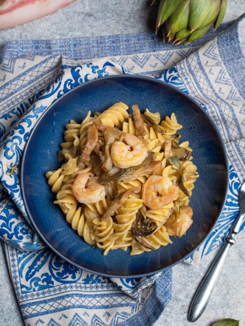 Carbonara di carciofi con fusilli, gamberi e strisce di guanciale in salsa cremosa