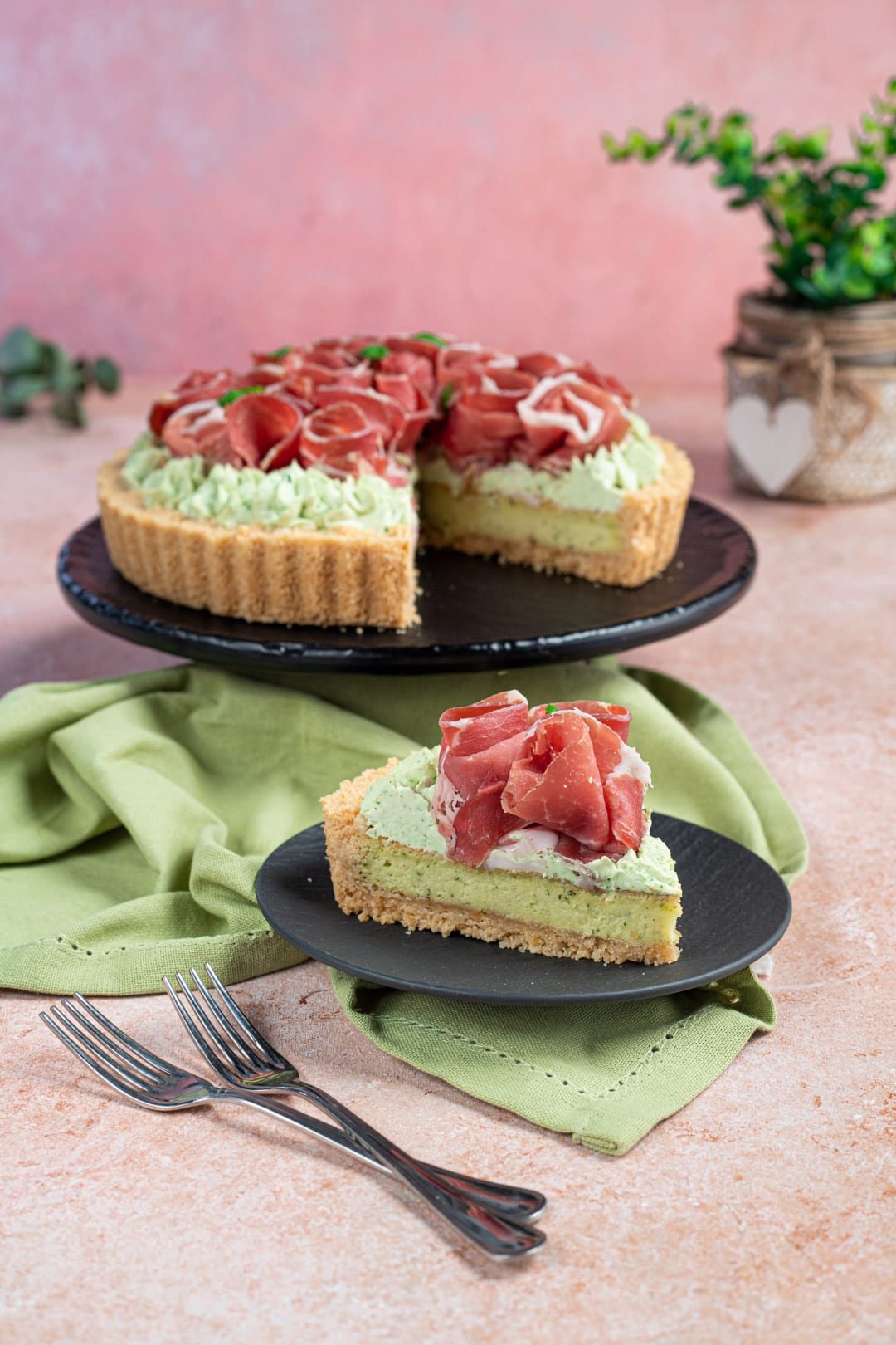 Fetta di crostata salata con crema al pistacchio e roselline di prosciutto crudo