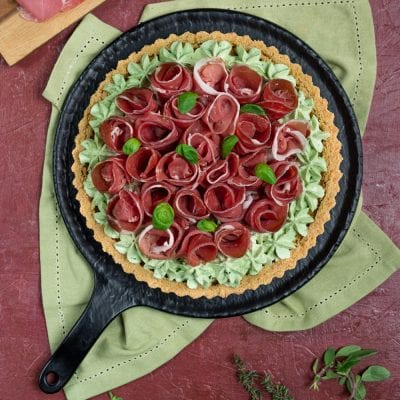 Crostata salata con roselline di crudo su crema al basilico e base di frolla dorata