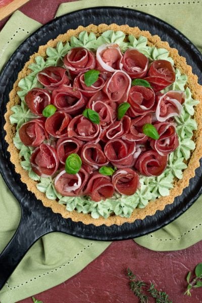 Crostata salata con roselline di crudo su crema al basilico e base di frolla dorata