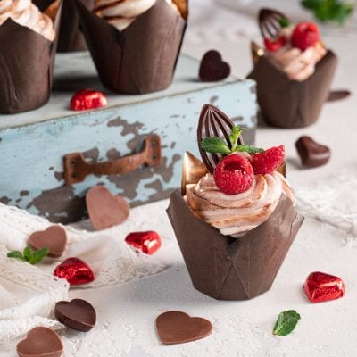 Cupcakes al fondente con crema al cioccolato, lamponi freschi e decorazione in cioccolato fondente