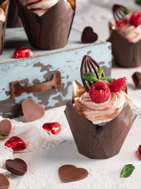 Cupcakes al fondente con crema al cioccolato, lamponi freschi e decorazione in cioccolato fondente