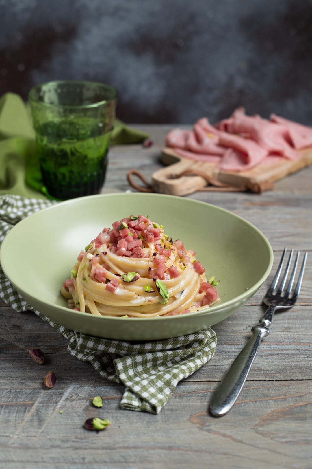 Nido di linguine con fonduta, cubetti di mortadella e pistacchi tritati