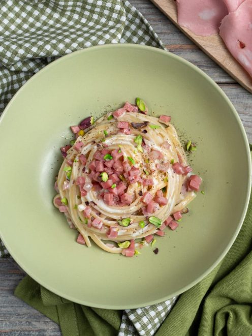 Linguine con fonduta e mortadella a cubetti, pistacchi tritati e pepe nero