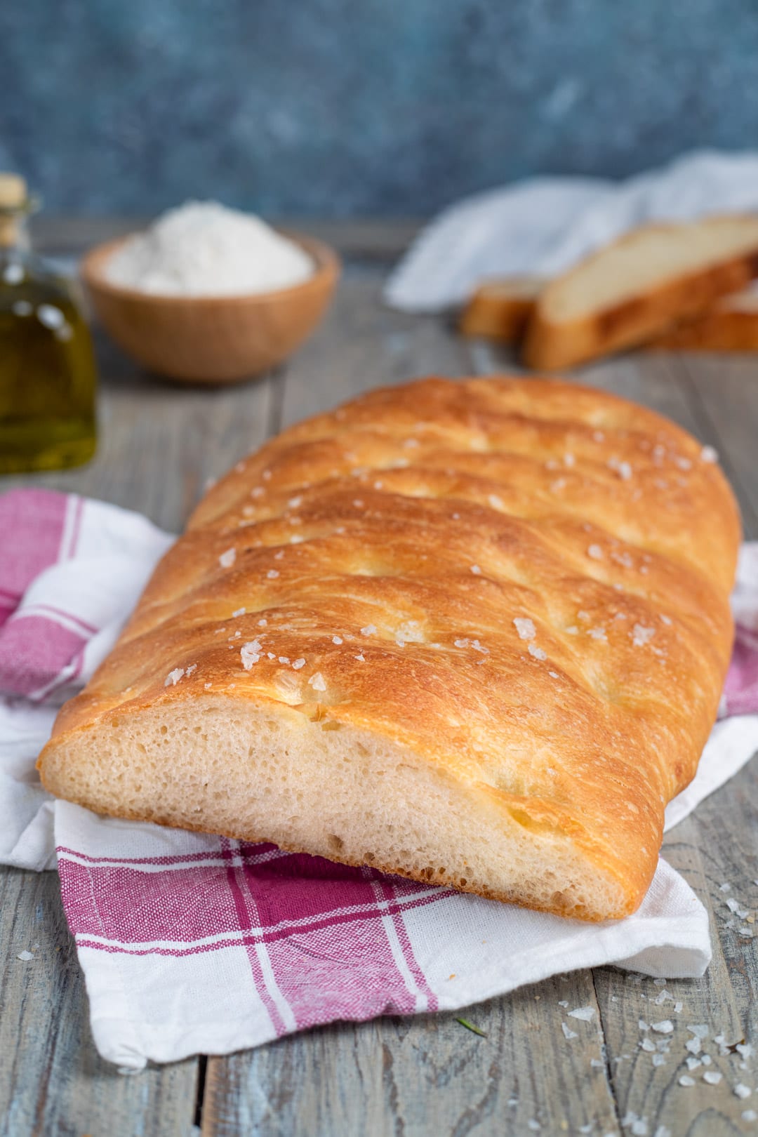 Pan focaccia appena sfornato con crosta dorata e cristalli di sale in superficie