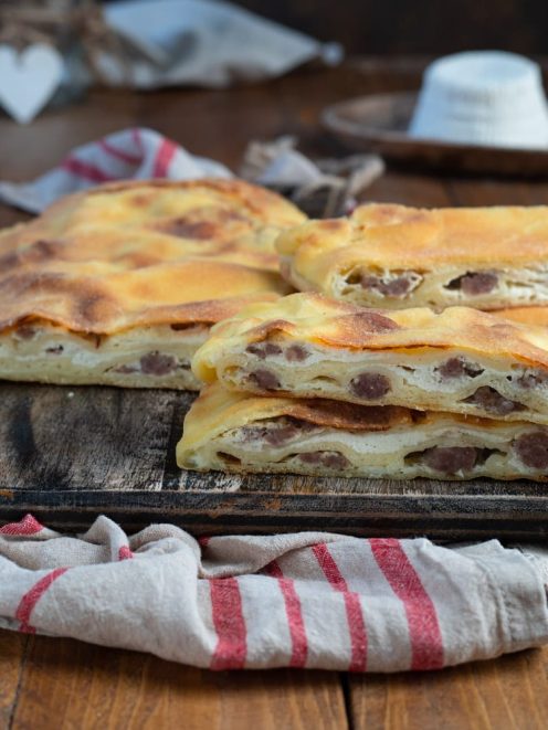 Scaccia ricotta e salsiccia tagliata a fette, con il ripieno di salsiccia a vista