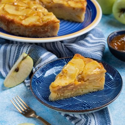 Torta invisibile di mele con fette di frutto caramellate in superficie, servita a spicchi
