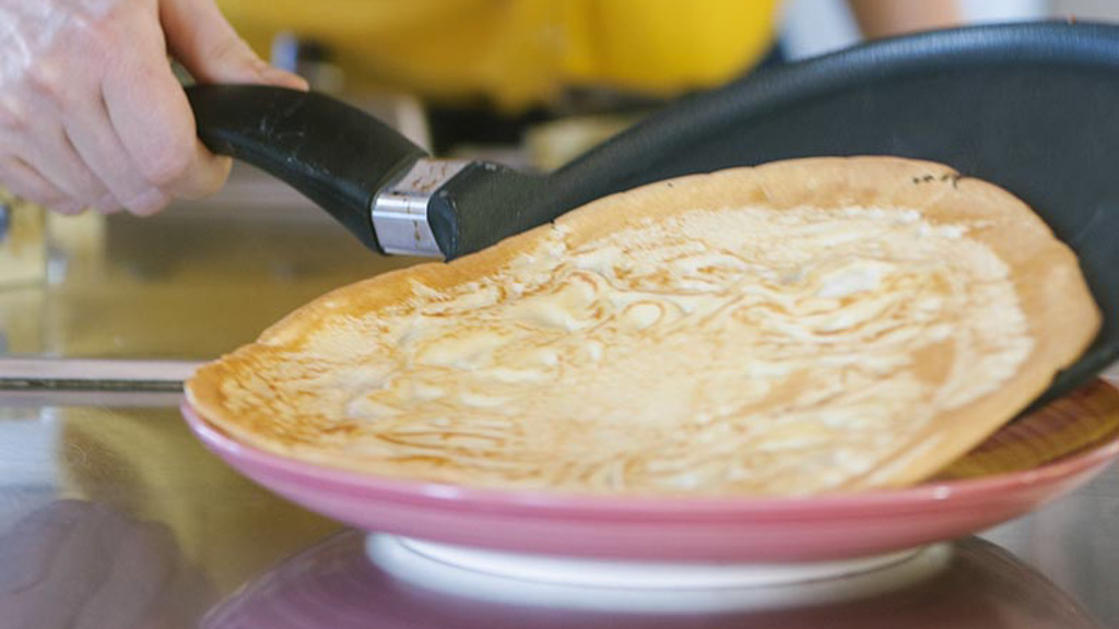 Crepes impilate una sull'altra su un piatto, pronte per essere farcite