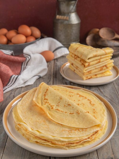 Crepes impilate e piegate, dorate con leggere macchie di cottura, pronte da farcire