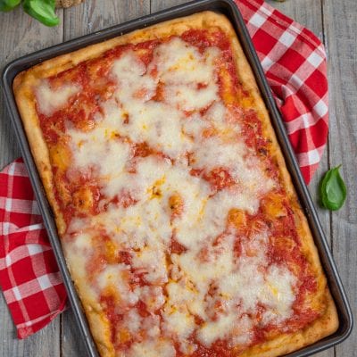 Pizza in teglia con pomodoro e mozzarella filante appena sfornata