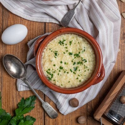 Stracciatella alla romana in cocotte di terracotta, cosparsa di parmigiano grattugiato e prezzemolo tritato
