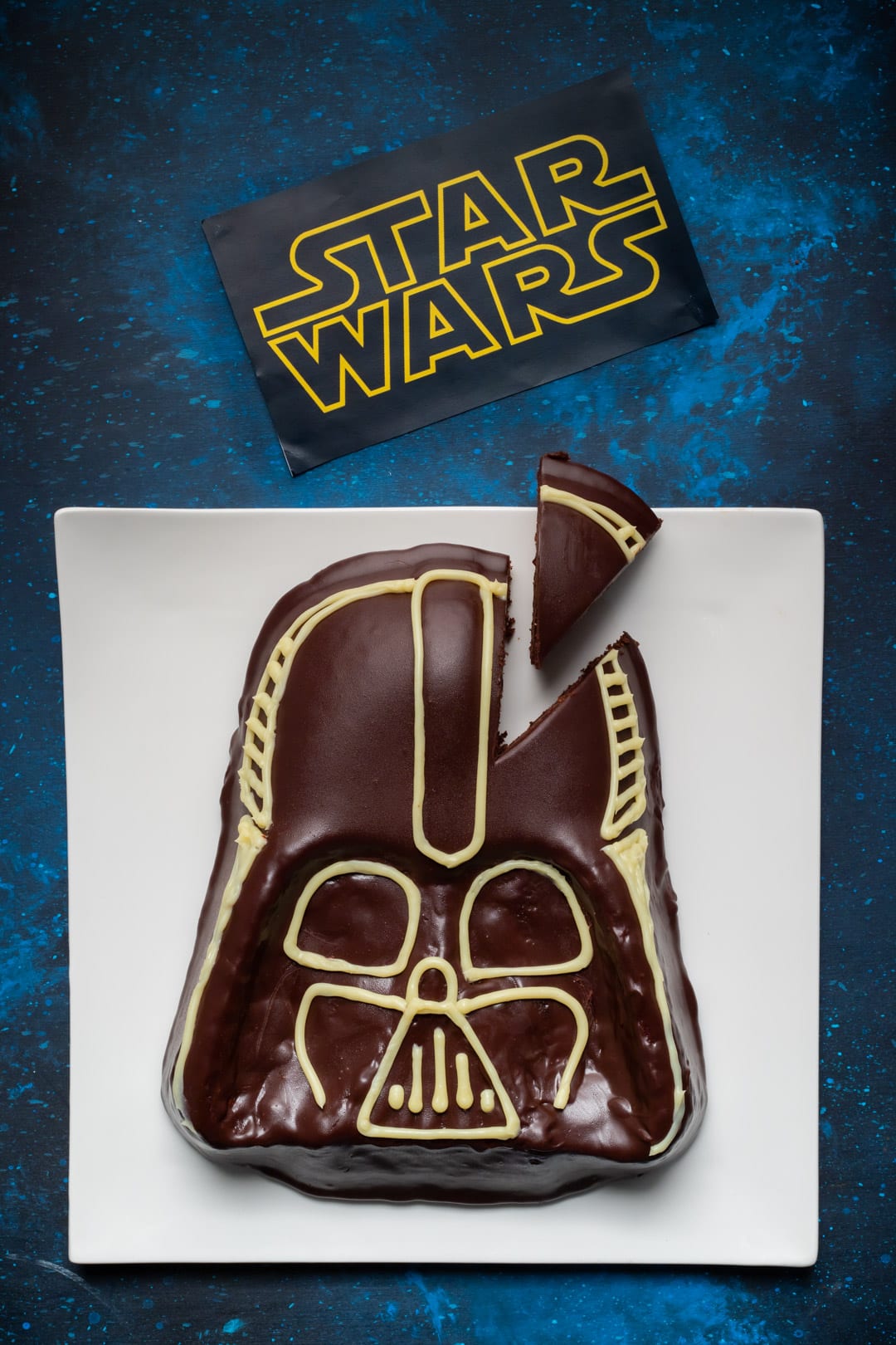 Torta Star Wars a forma di casco di Darth Vader con glassa al cioccolato e decorazioni in cioccolato bianco