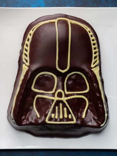 Torta Star Wars a forma di casco di Darth Vader glassata al cioccolato fondente con decorazioni in cioccolato bianco