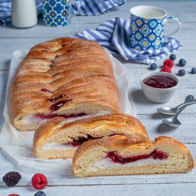 Treccia con ricotta e confettura di frutti rossi affettata, con il ripieno cremoso e la marmellata ben visibili