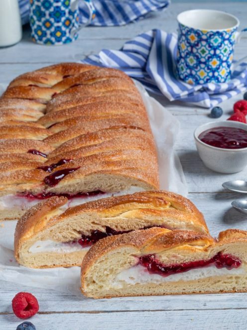 Treccia con ricotta e confettura di frutti rossi affettata, con il ripieno cremoso e la marmellata ben visibili