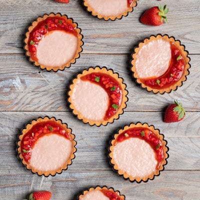 Crostatine con panna cotta alle fragole guarnite con coulis e foglioline di menta
