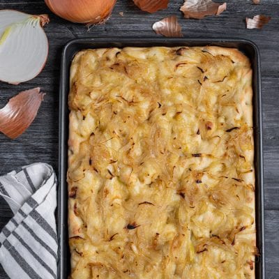 Focaccia con le cipolle appena sfornata, ricoperta di cipolle caramellate dorate in teglia