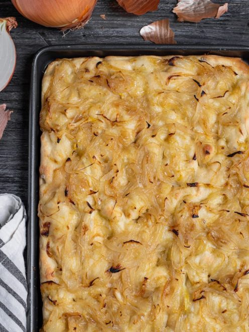 Focaccia con le cipolle appena sfornata, ricoperta di cipolle caramellate dorate in teglia
