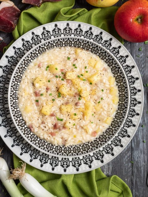 Risotto speck e mele con cubetti di mela, pezzetti di speck, pepe nero e erba cipollina