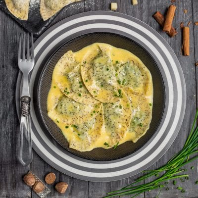 Schlutzkrapfen conditi con burro fuso, semi di papavero e erba cipollina tritata