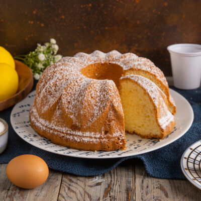 Torta 7 vasetti a ciambella spolverata di zucchero a velo con una fetta tagliata in mostra