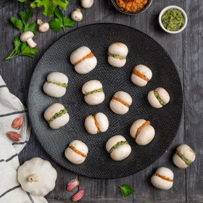 Baci di Champignon farciti con pesto verde e crema di peperoni, pronti da servire