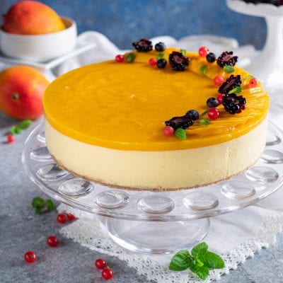 Cheesecake al mango con glassa lucida e frutti di bosco freschi e foglioline di menta