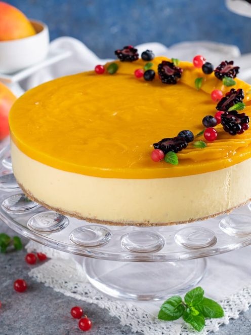 Cheesecake al mango con glassa lucida e frutti di bosco freschi e foglioline di menta