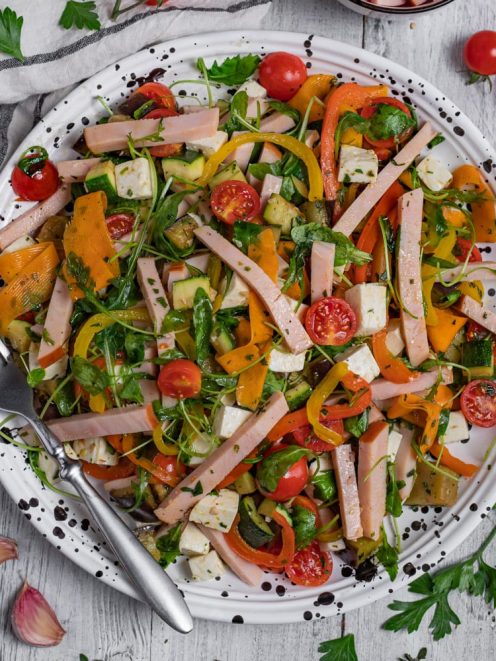 Insalata di tacchino con rucola, pomodorini, peperoni grigliati, zucchine e cubetti di formaggio