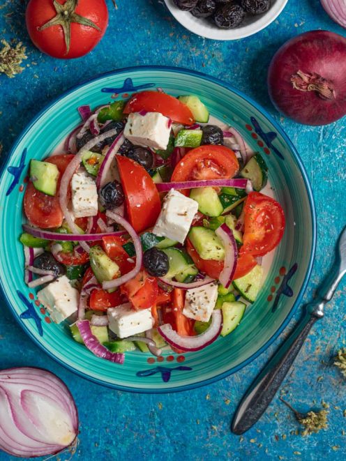 Insalata greca con pomodori, cetrioli, feta a cubetti, olive nere e cipolla rossa