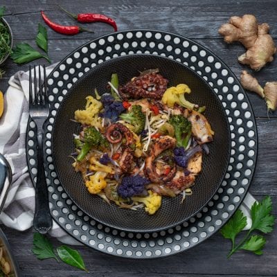 Polpo all'orientale con tentacoli grigliati, cavolfiore colorato, broccoli, germogli e peperoncino