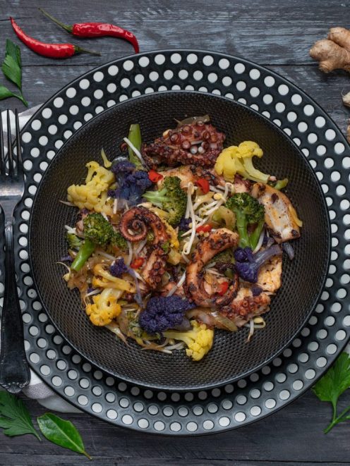 Polpo all'orientale con tentacoli grigliati, cavolfiore colorato, broccoli, germogli e peperoncino