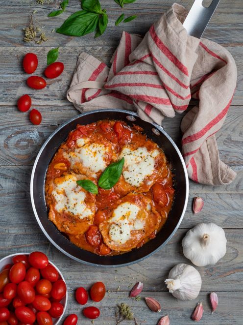 Fettine di vitello alla pizzaiola in padella con mozzarella filante, pomodorini e basilico fresco