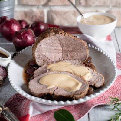Arrosto di vitello alla senape affettato con salsa cremosa e cipolle rosse caramellate