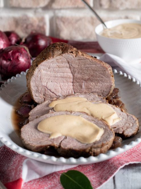 Arrosto di vitello alla senape affettato con salsa cremosa e cipolle rosse caramellate