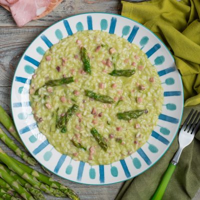 Risotto asparagi taleggio e prosciutto cremoso con punte di asparagi verdi e cubetti di prosciutto