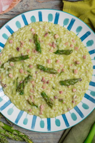 Risotto asparagi taleggio e prosciutto cremoso con punte di asparagi verdi e cubetti di prosciutto