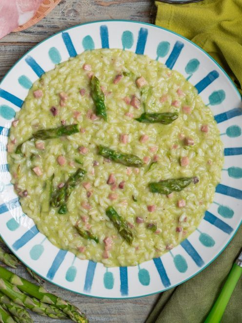 Risotto asparagi taleggio e prosciutto cremoso con punte di asparagi verdi e cubetti di prosciutto
