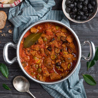Spezzatino di vitello con olive verdi e nere in ricco sugo di pomodoro con foglia di alloro