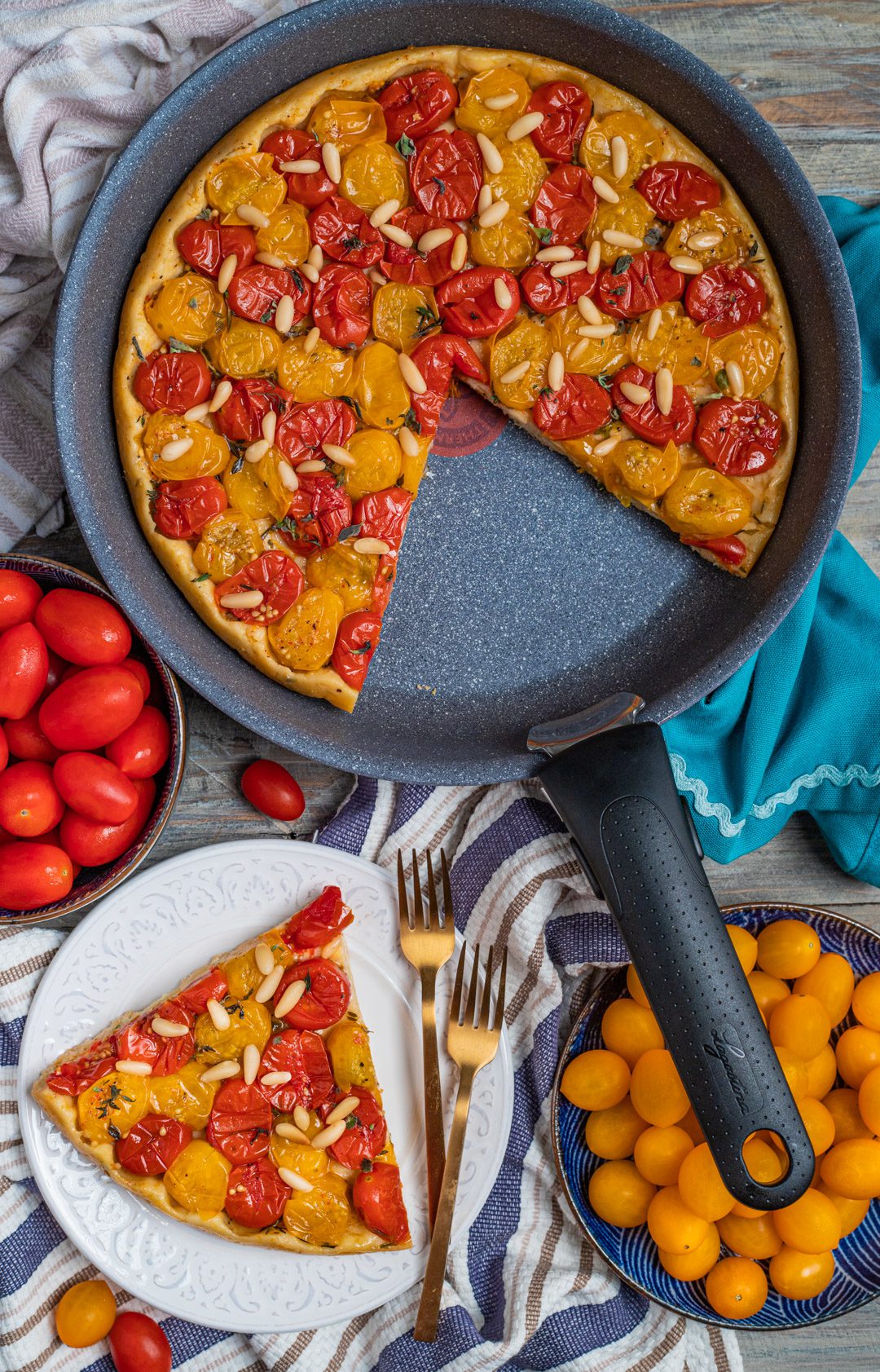 Fetta di tarte tatin salata con pomodorini rossi e gialli e pinoli su piatto