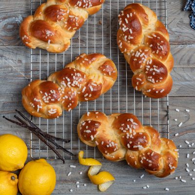Treccine allo yogurt appena sfornate con granella di zucchero, accostate a limoni e bacche di vaniglia