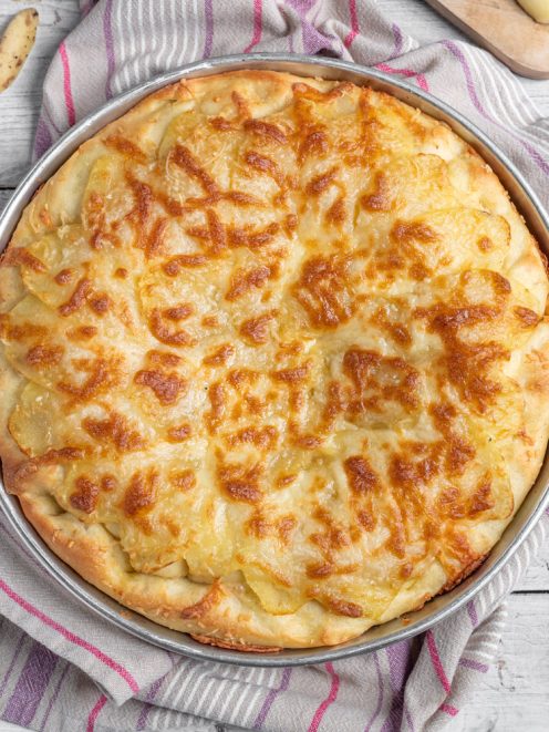 Focaccia con formaggio e patate appena sfornata, con superficie dorata e gratinata