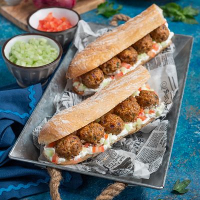 Panino con polpette di vitello farcito con crema, pomodoro a dadini e cetriolo
