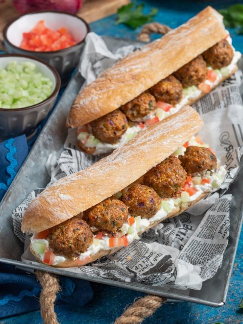 Panino con polpette di vitello farcito con crema, pomodoro a dadini e cetriolo