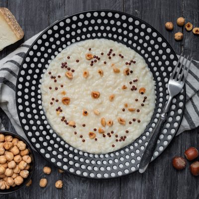 Risotto al Castelmagno e nocciole tostate guarnito con perle di aceto balsamico