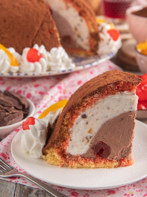 Zuccotto toscano in fetta con ripieno di crema al cioccolato, panna e ciliegie candite