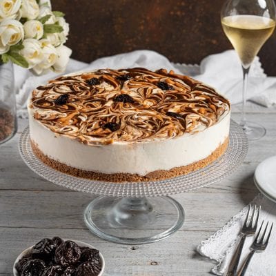 Cheesecake con prugne e caramello salato, superficie marmorizzata e base di biscotto sbriciolato