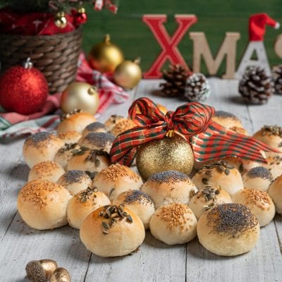 Ghirlanda di pane con panini disposti a corona, guarniti con semi di papavero, sesamo e zucca