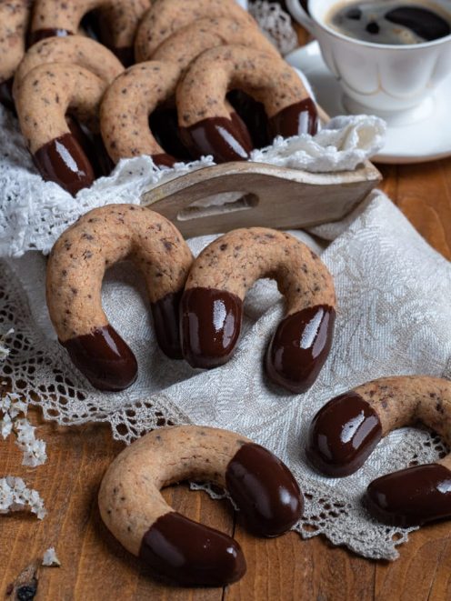 Kipferl al cioccolato a forma di ferro di cavallo con punte glassate su tovagliolo di pizzo